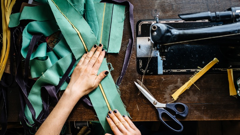 mains d'une femme cousant des tissus